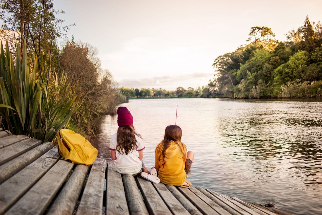 Two girls fishing by the river