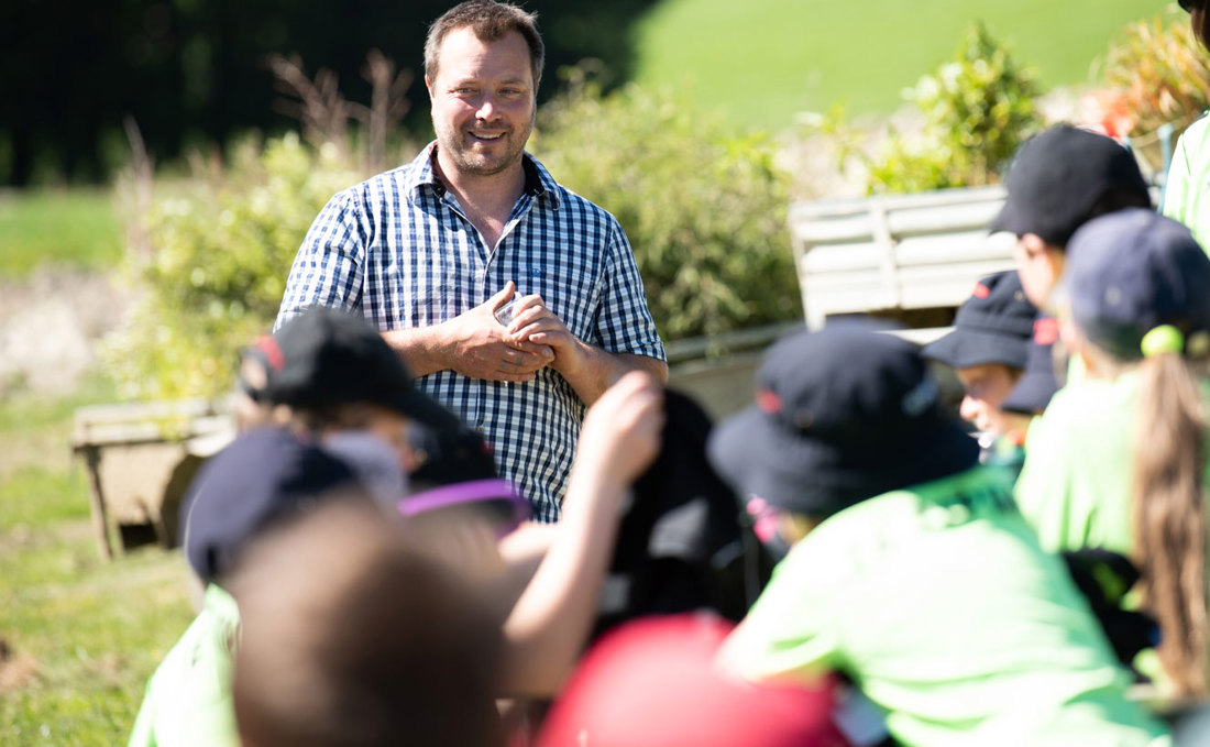 Dairy farmer Chris Giles talking to primary school children on a farm visit